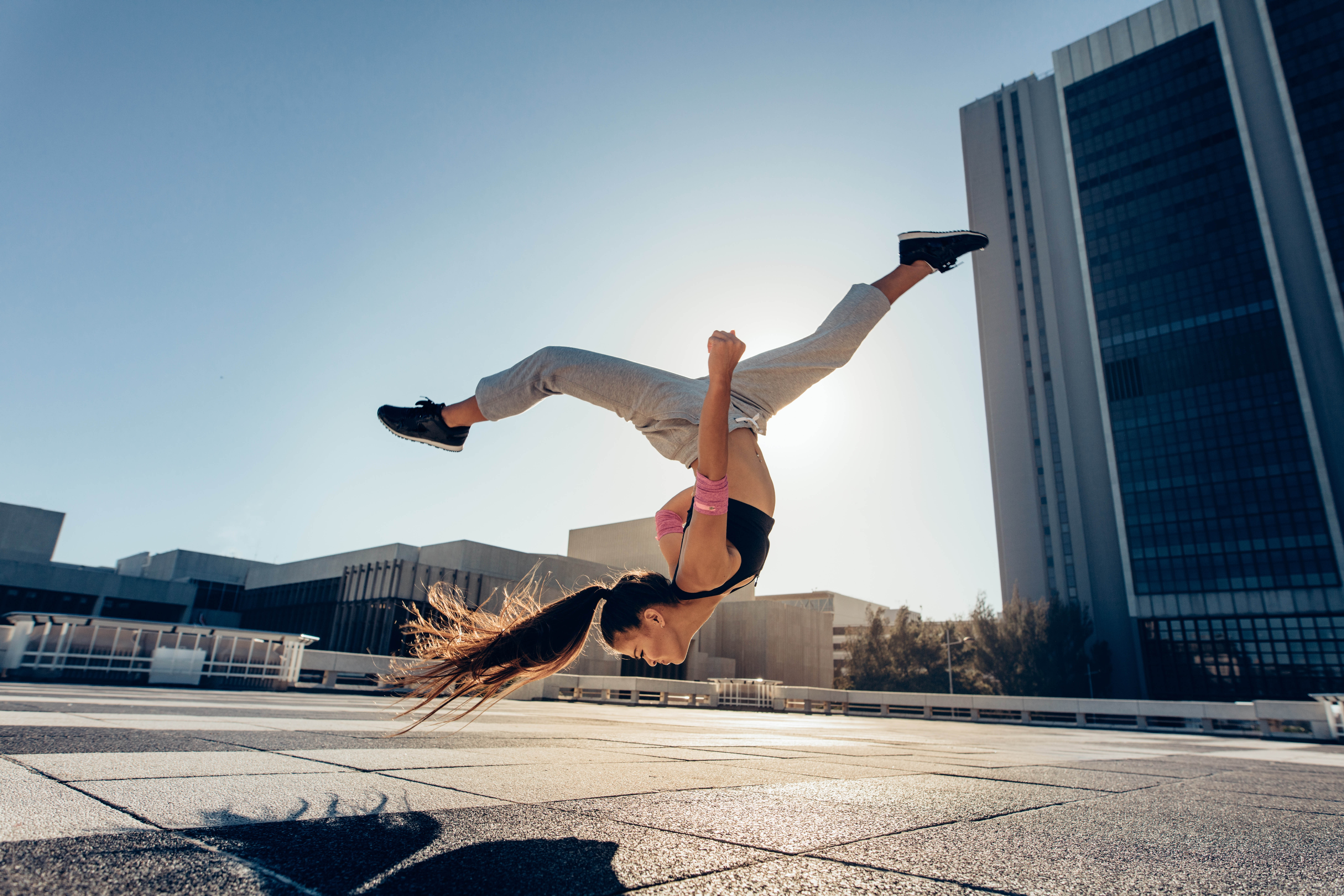 Young athletic woman does a flip, camera captures her upside down with her legs splayed Young athletic woman does a flip, camera captures her upside down with her legs splayed